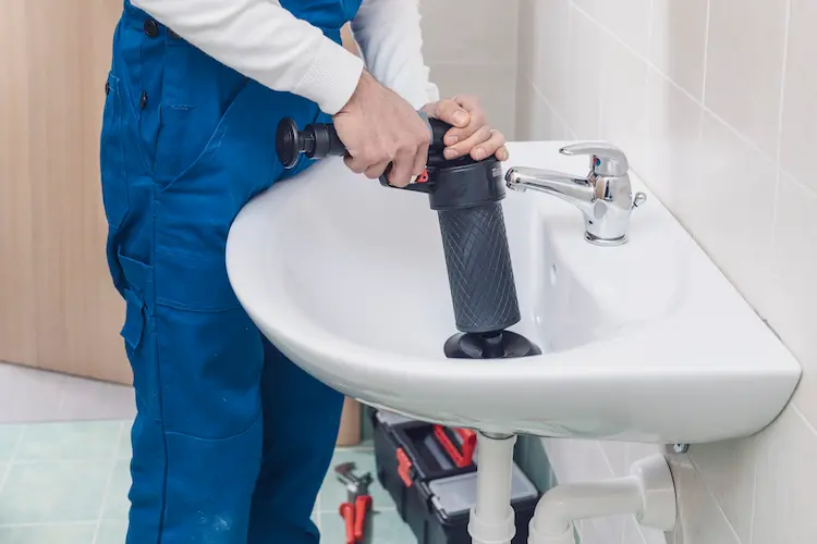 Idraulico che ripara un tubo in una casa a Pinerolo